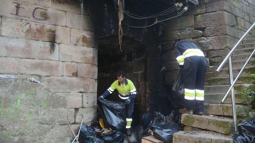 Personal de Cespa retira de la zona en la que se produjo el incendio todo el material calcinado que acumulaba este hombre. // Rafa Vázquez