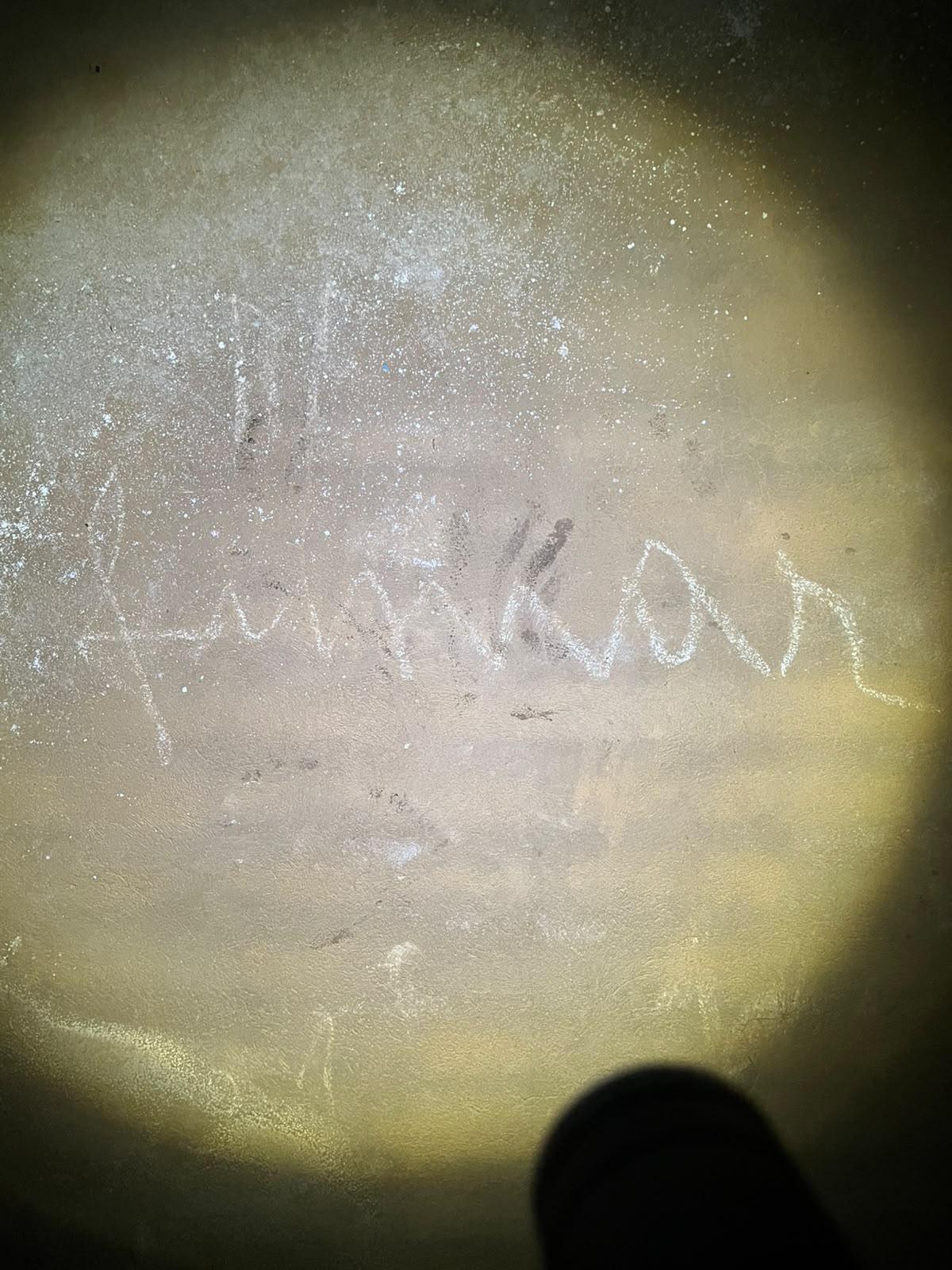 Las letras escritas en la pared con tiza.