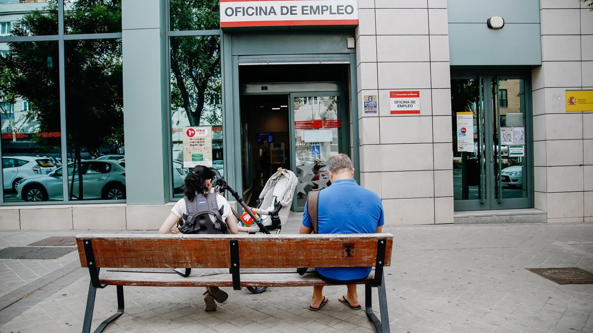 Archivo - Dos personas esperan fuera de una oficina de empleo
