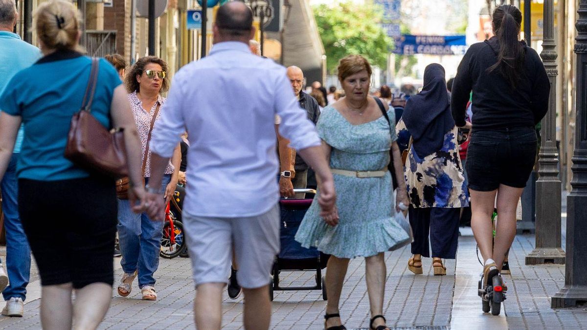 Una usuaria de patinete eléctrico circula por un vial semipetonal de Vila-real abarrotado de transeúntes.