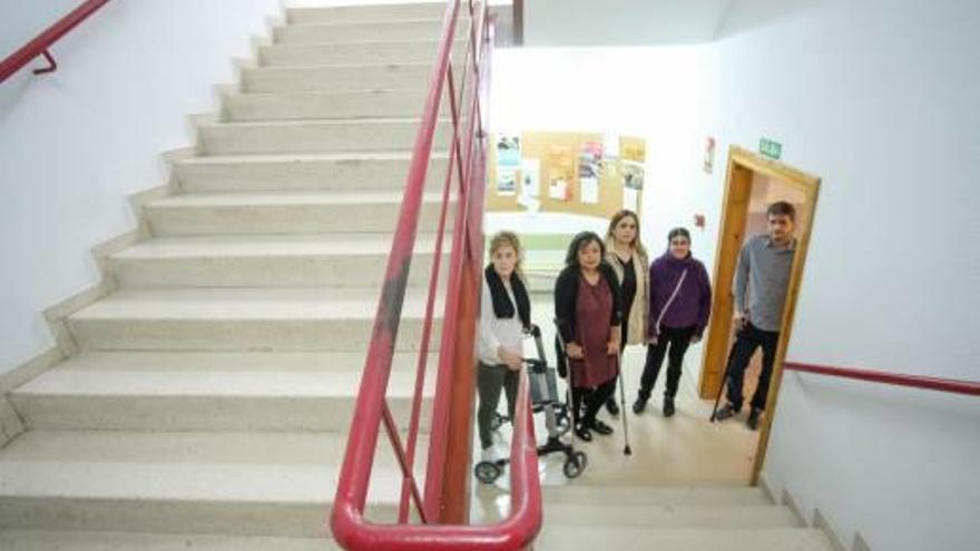 Personas con discapacidad ante las escaleras que no pueden subir de la Escuela Oficial de Idiomas.