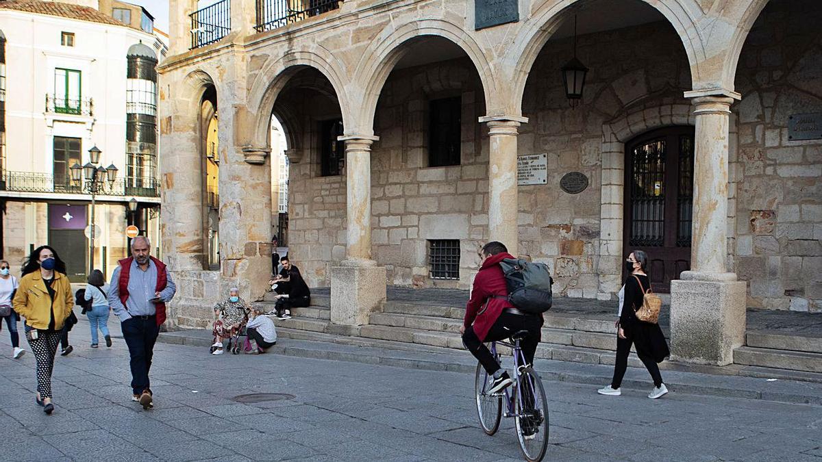 Un ciclista pasa frente al cuartel de la Policía Municipal, en la Plaza Mayor.