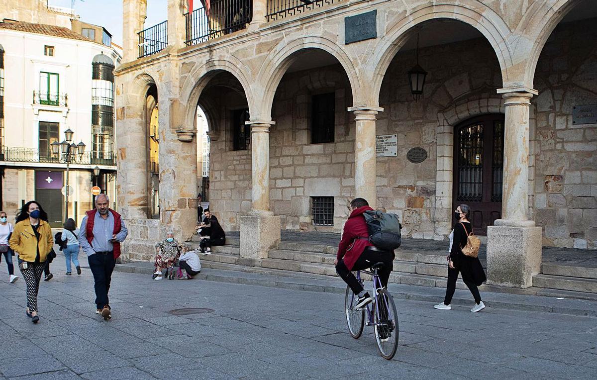 Un ciclista pasa frente al cuartel de la Policía Municipal, en la Plaza Mayor. | Ana Burrieza