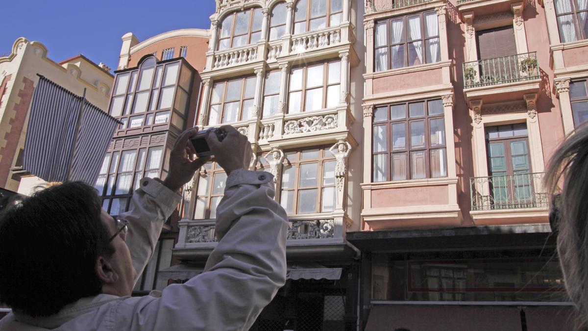 Un hombre fotografía el edificio de las Cariátides.