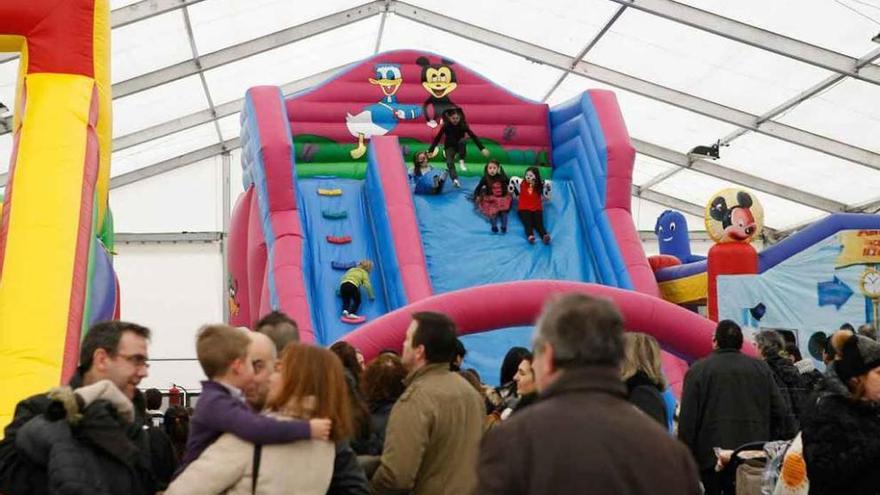 Familias enteras en la carpa de la Plaza Mayor disfrutan de los juegos infantiles.