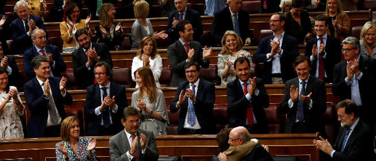 El ministro Cristobal Montoro recibe la felicitación de la vicepresidenta tras aprobarse las cuentas.