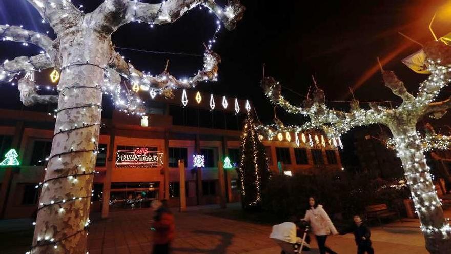 El Ayuntamiento y los árboles de la plaza, con luces navideñas.
