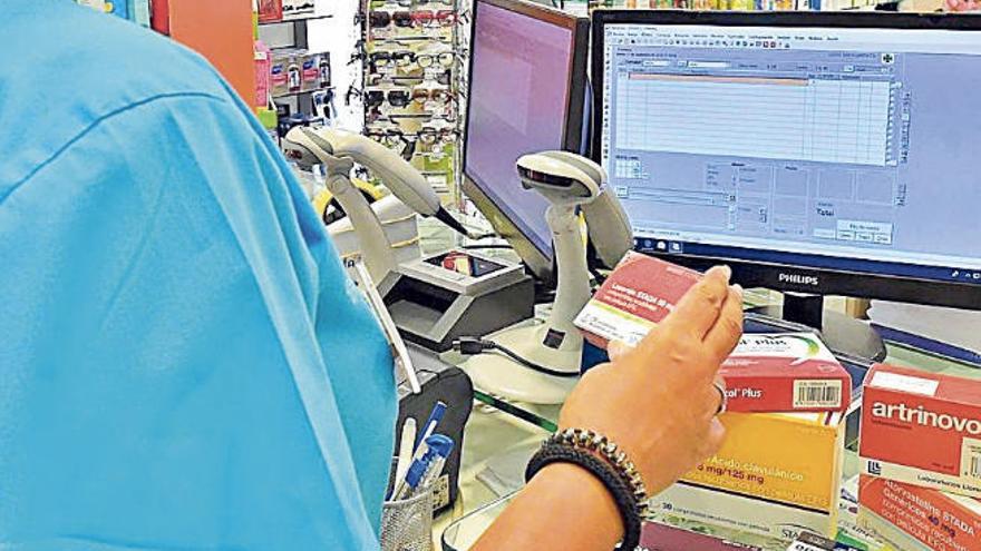 Una empleada dispensa medicamentos en una farmacia.