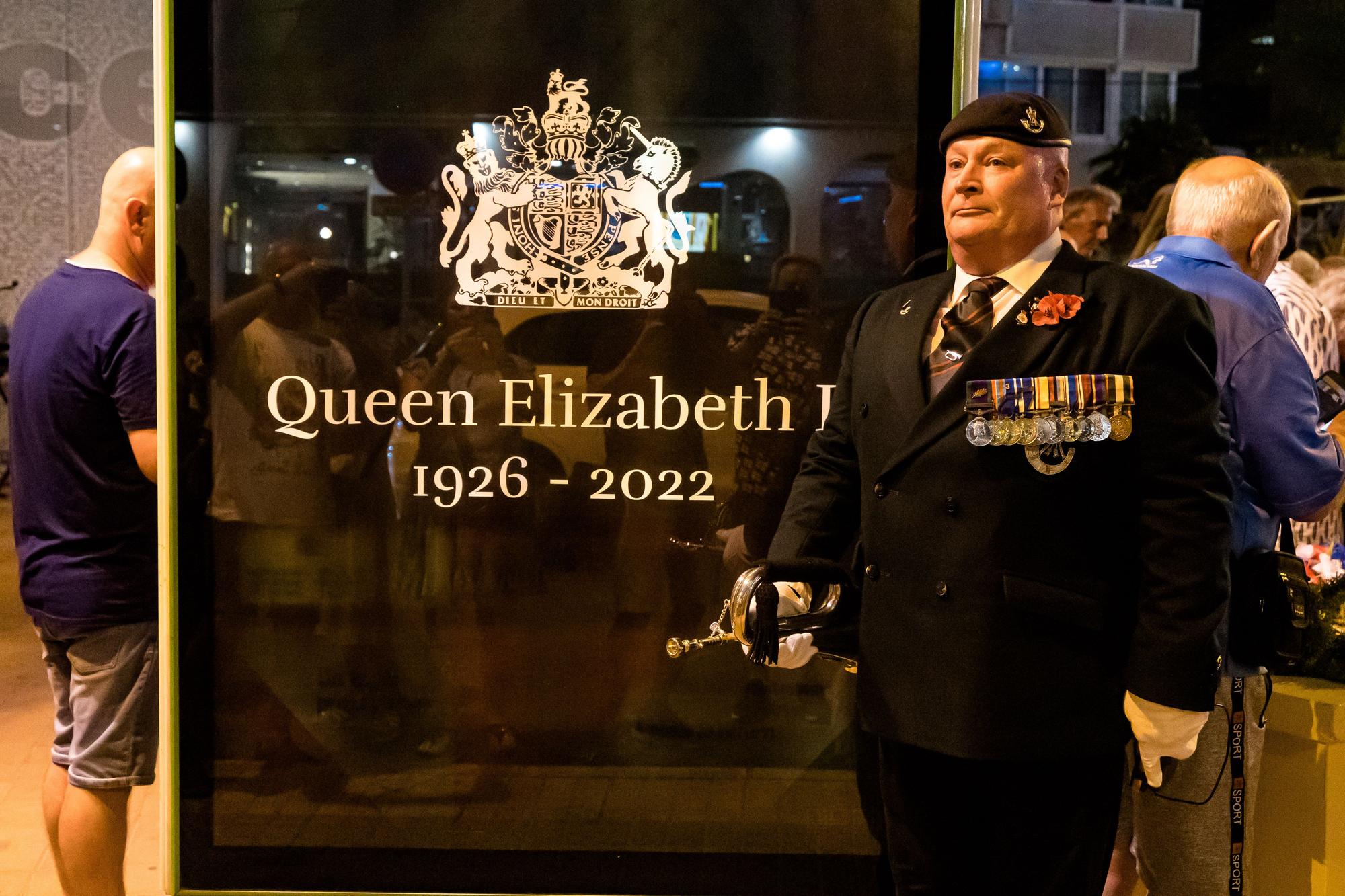 Británicos residentes y turistas de Benidorm rinden un sentido homenaje a Elizabeth II en el espacio habilitado por el Ayuntamiento en la zona inglesa de la ciudad.