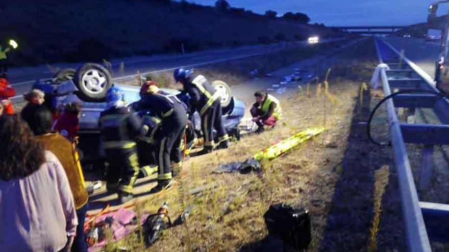 Sanitarios y bomberos trabajan en el lugar del siniestro para atender al joven herido.