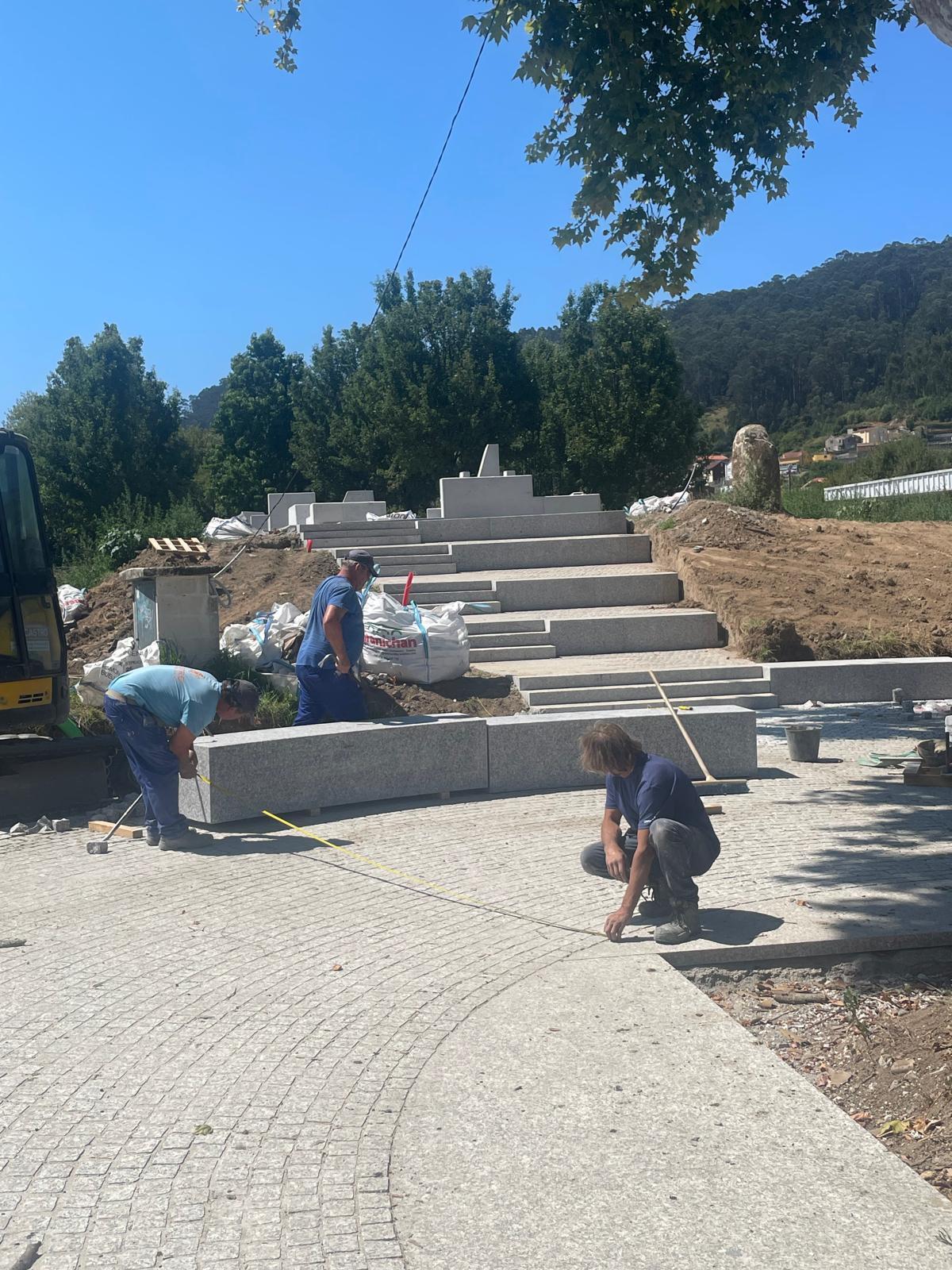 Operarios trabajando ya en la colocación de los bancos de piedra en el recinto.