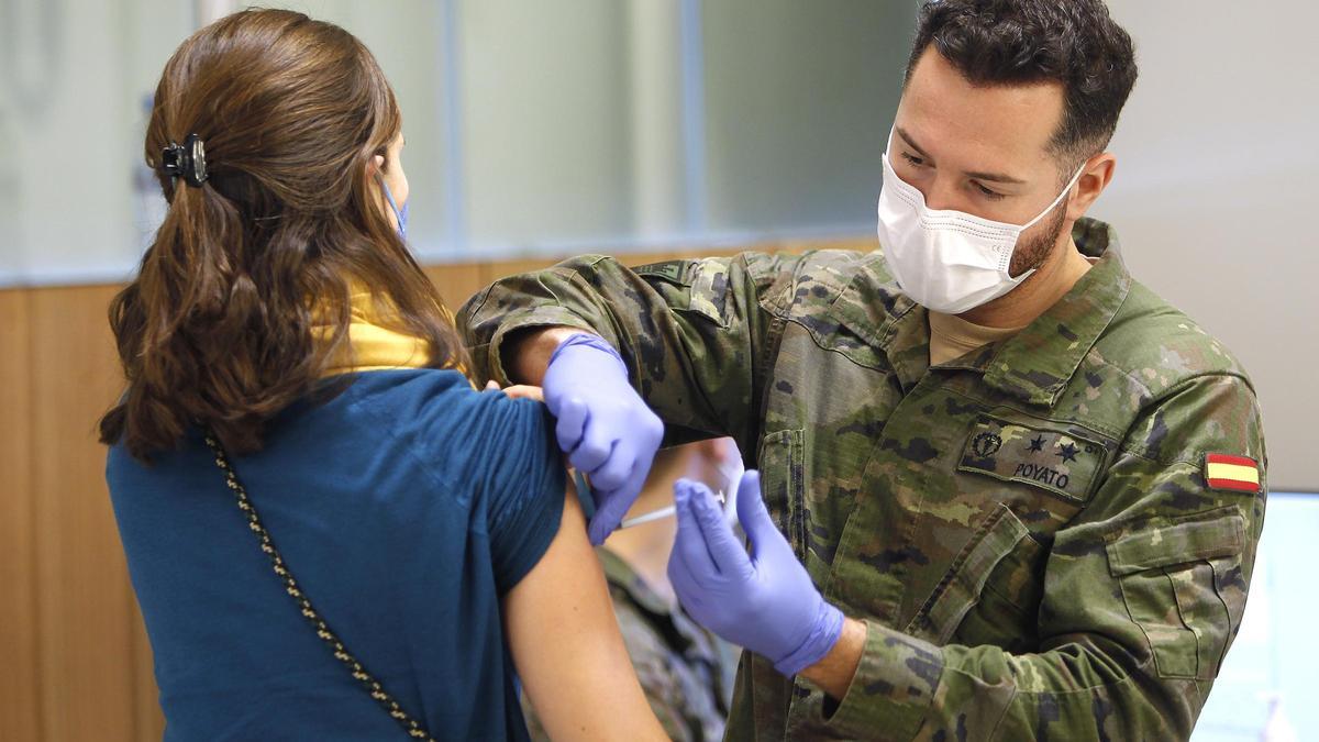 Un militar de las Fuerzas Armadas vacuna a una mujer en Palma.