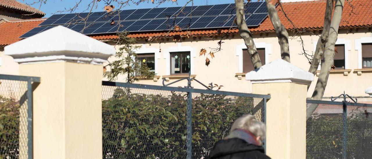 Un hombre pasea junto al colegio San José de Calasanz, donde ya se han colocado los paneles solares.