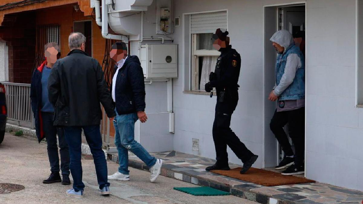 El arrestado tras el asesinato sale de su casa custodiado por la Policía.