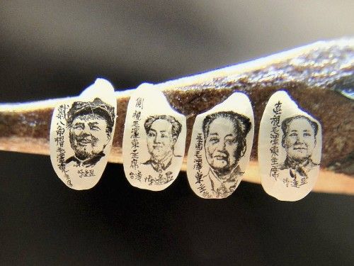 Miniature portraits of former Chinese Chairman Mao on grains of rice, created by Taiwanese artist Chen, are displayed on a pencil in Taipei
