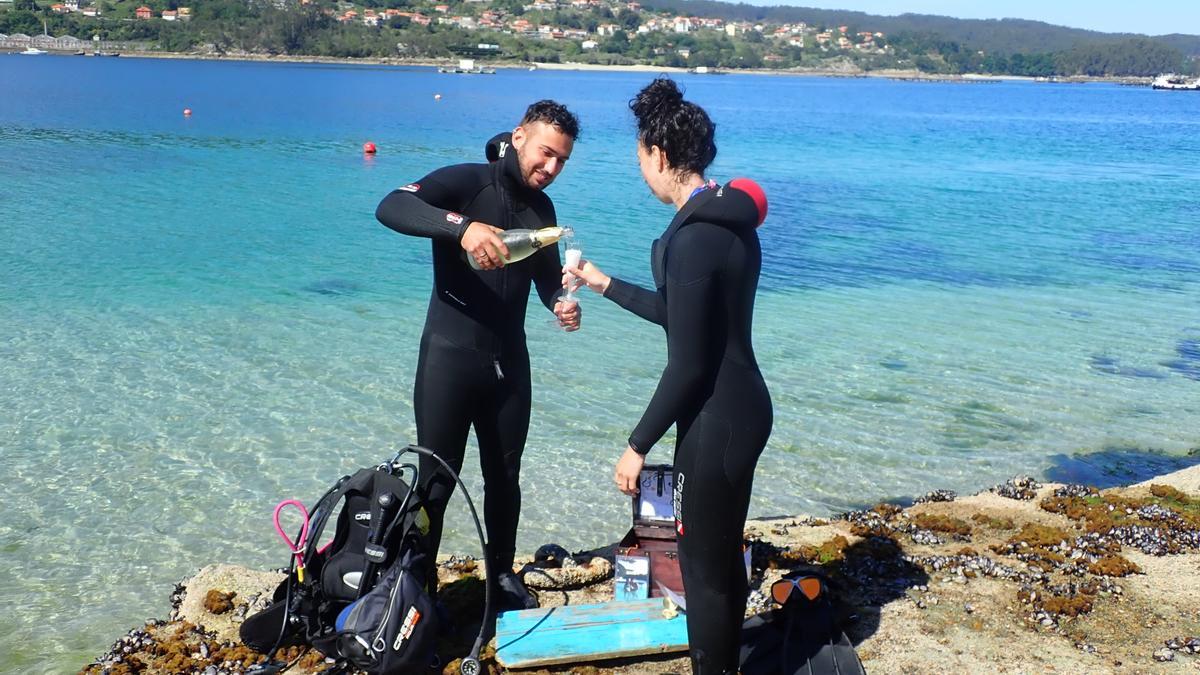 La pareja se dispone a brindar una vez acabada la inmersión en la Ría de Aldán.