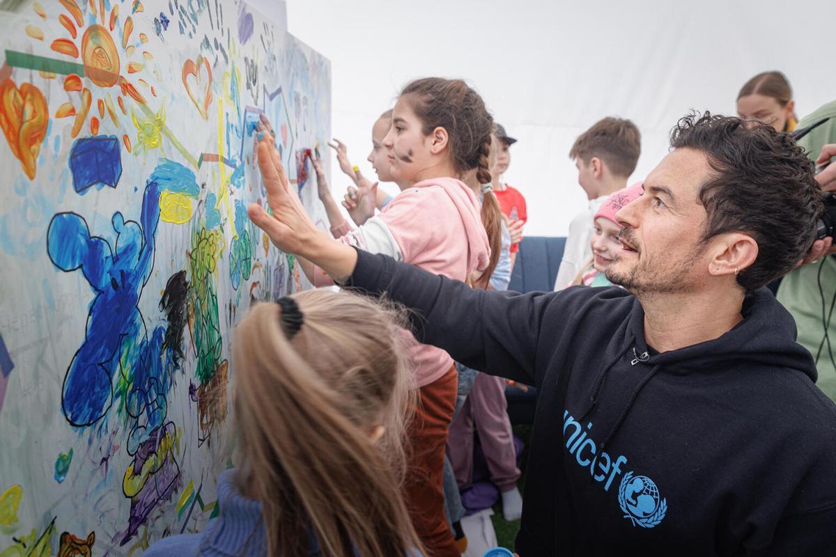 El actor Orlando Bloom, pintando un mural con los niños de Irpin, durante su vista a Ucrania como Embajador de Buena Voluntad, el pasado 26 de marzo de 2023.