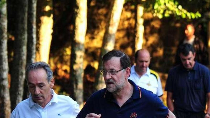 Mariano Rajoy, ayer, en Armenteira con José Benito Suárez, y al fondo Rafael Louzán y Javier Guillén.  // Iñaki Abella