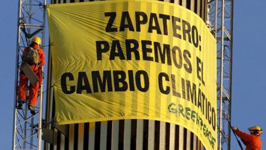 Varios activistas de Greenpeace colcan una panacarta en el obelisco.