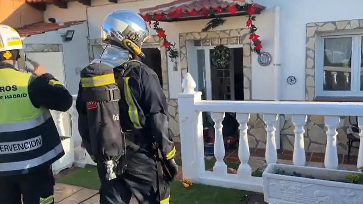 Bomberos junto a la casa en la que encontraban los cadáveres de la pareja.