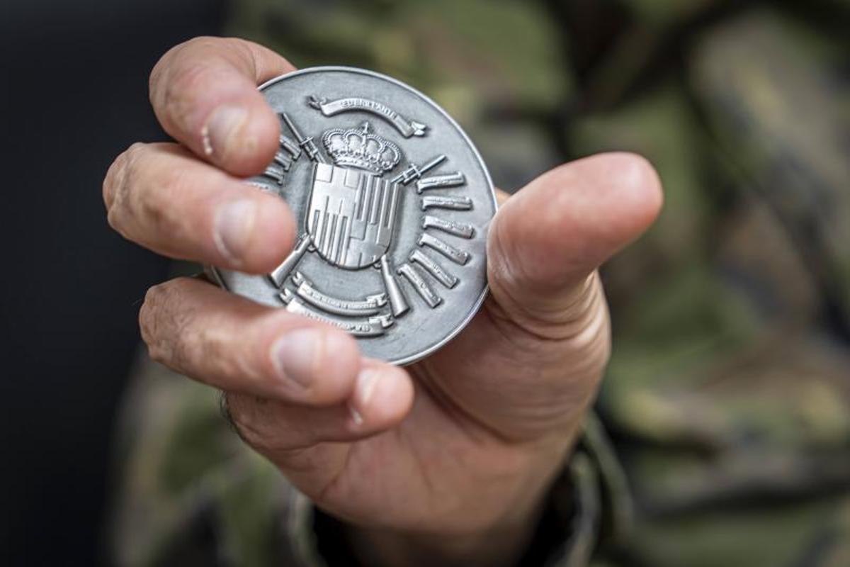 En la mano del coronel Pedro Valdés, la moneda del regimiento Barcelona 63 que regala a alumnos ucranianos destacados.