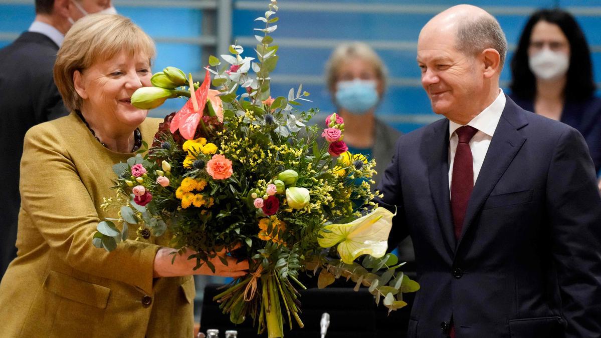 Angela Merkel recibe un ramo de flores.