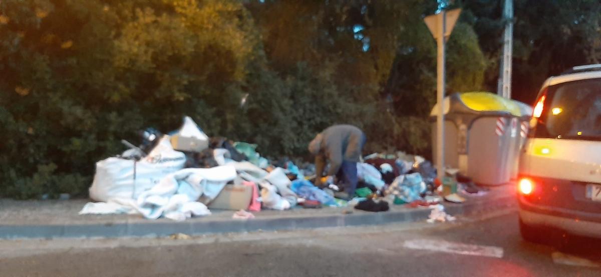 Munts d’escombraries fora dels contenidors a un carrer del barri.