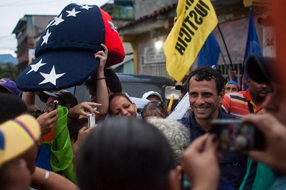 Partidaris del candidat opositor Henrique Capriles el saluden durant una concentració a Cúa (Veneçuela).
