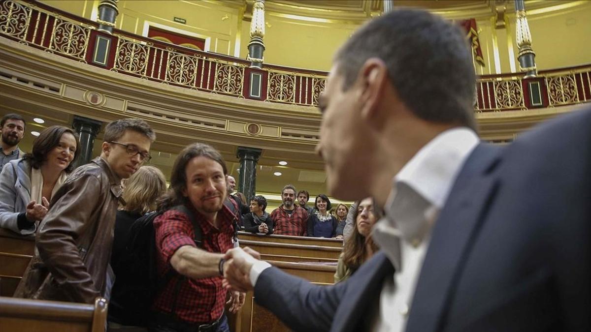 Los líderes del PSOE y de Podemos, Pedro Sánchez y Pablo Iglesias, se saludan en el hemiciclo del Congreso.