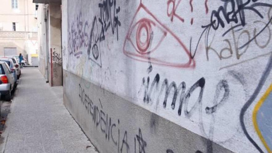 Una façana plena de pintades en un carrer de Girona.