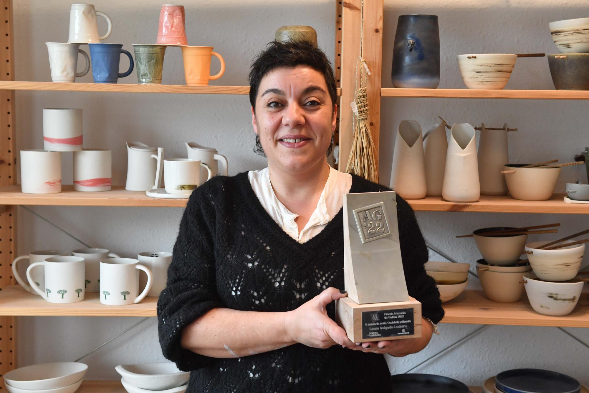 Laura Delgado con los vasos tiki ganadores, una combinación de culturas entre Polinesia y Galicia, y otras obras realizadas por esta ceramista en su taller de Cambre, en el que también da clases a pequeños grupos.