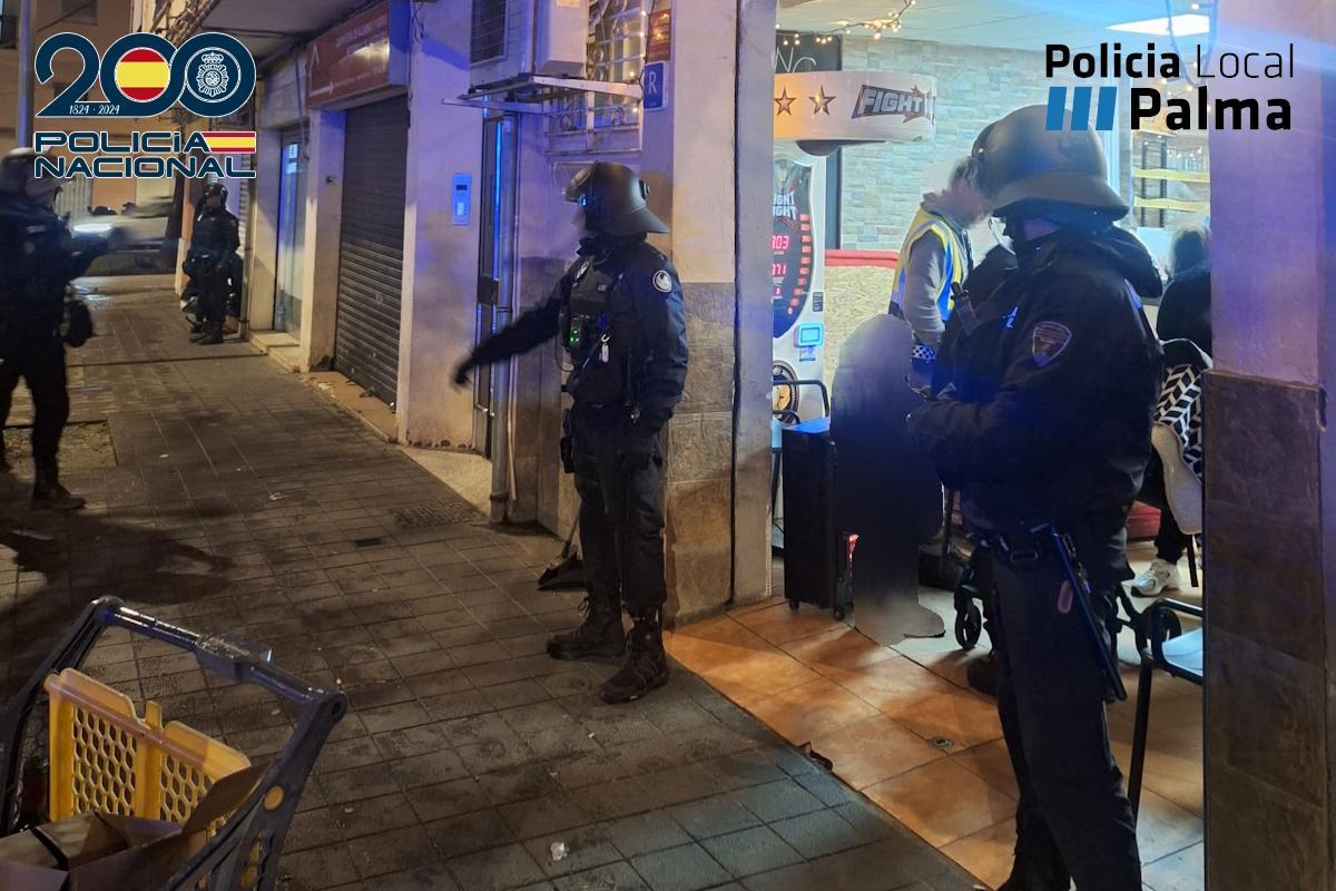 Agentes de Policía custodian la entrada del bar durante la inspección.