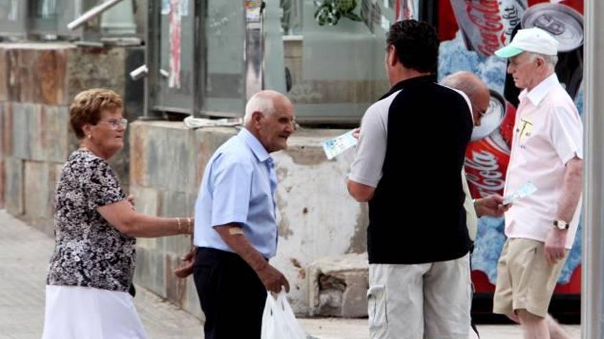 Un hombre intenta convencer a varias turistas para apuntarse a una de las excursiones que organizan fuera de Benidorm