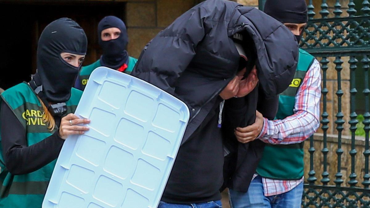 Agentes de la Unidad Central Operativa (UCO) de la Guardia Civil se llevan a un detenido durante el registro de una propiedad en la localidad gallega de Vilagarcía de Arousa este miércoles en el marco una operación contra el narcotráfico en Galicia