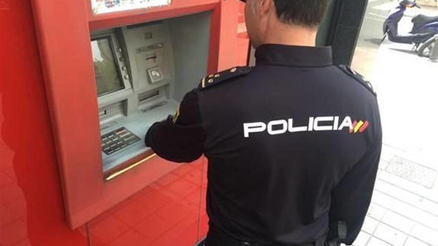 Un policía nacional junto a un cajero automático de Alicante.