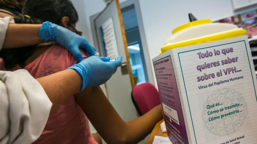 Una enfermera vacuna a una joven contra el virus del papiloma humano.