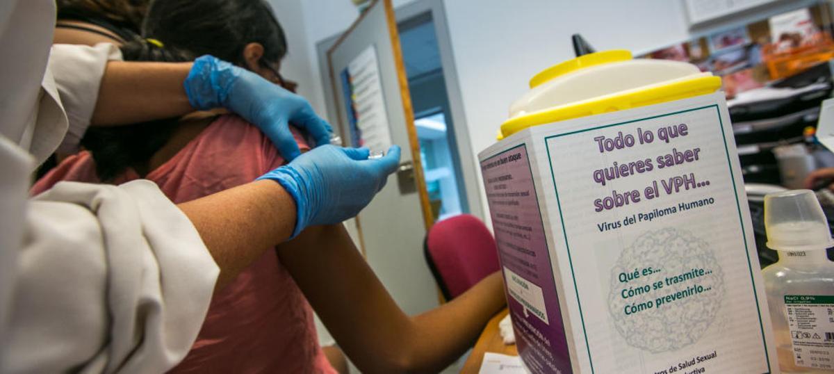 Una enfermera vacuna a una joven contra el virus del papiloma humano.