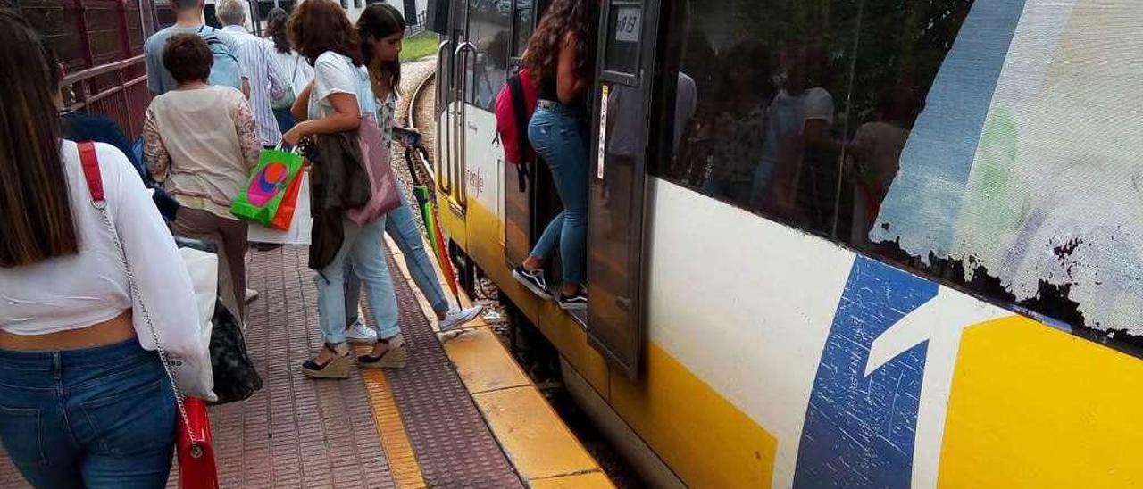 Pasajeros subiendo y bajando del tren en el transbordo de El Berrón.