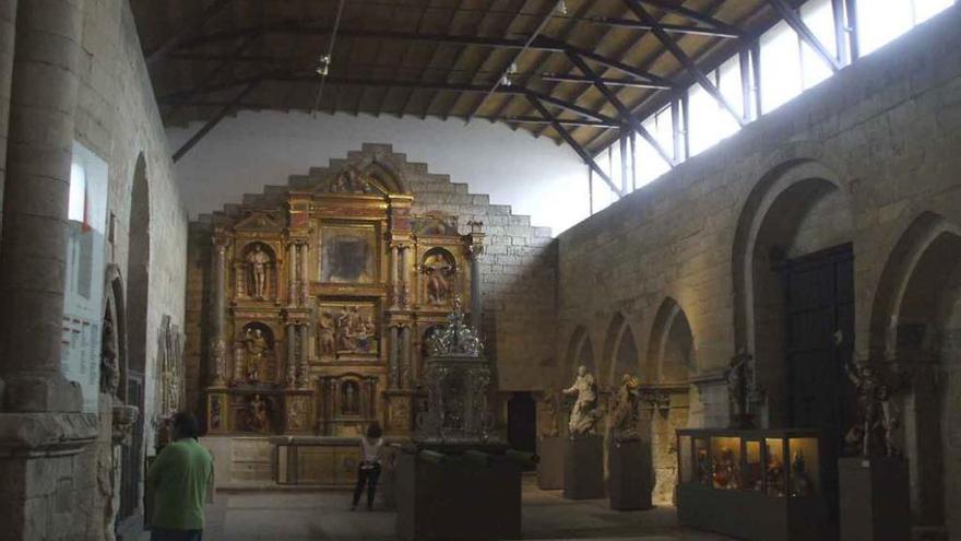 Dos turistas admiran las esculturas y el retablo que alberga la capilla de La Majestad. Foto
