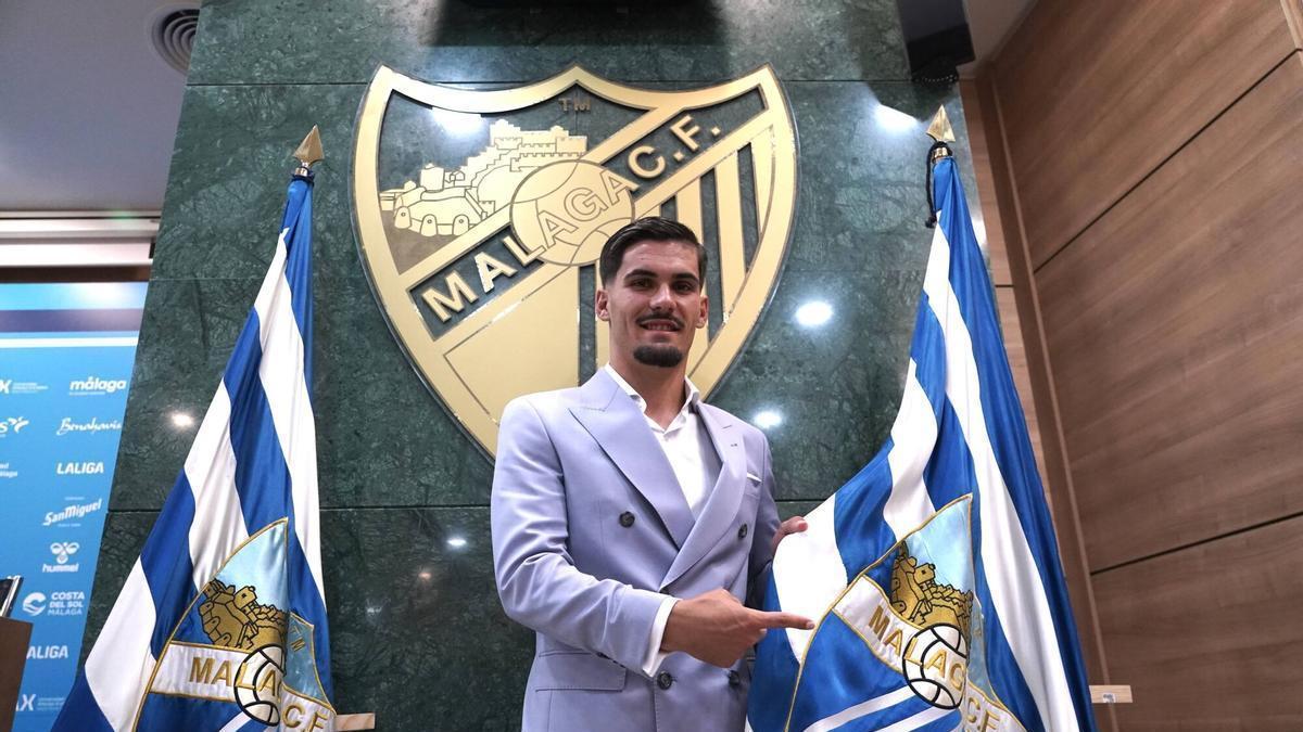 Chupe señala la bandera del Málaga CF tras la rueda de prensa de renovación.