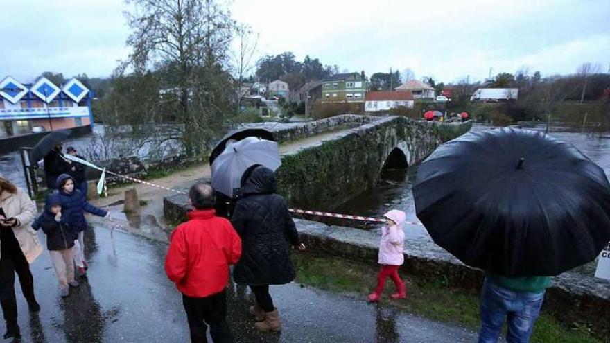 Varios vecinos se acercaron a ver el nivel del Tea en el puente de Os Remedios. // A. Hernández