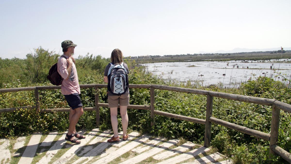 Dos visitantes observan las lagunas de s'Albufera desde uno de los miradores.