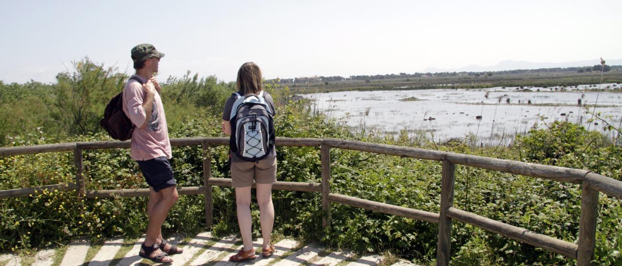 Dos visitantes observan las lagunas de s&#039;Albufera desde uno de los miradores.