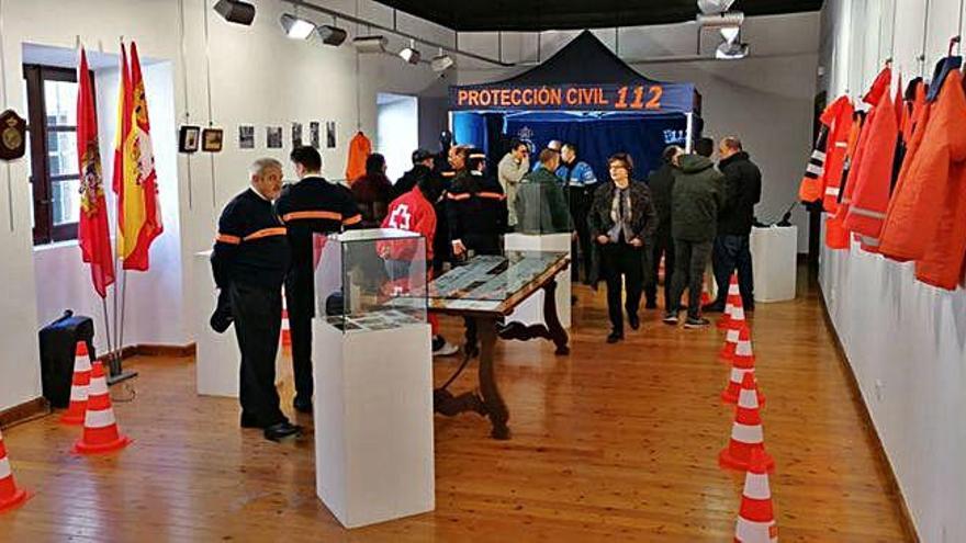 Invitados a la inauguración de la exposición admiran los fondos, el material y las fotografías de los voluntarios de Protección Civil