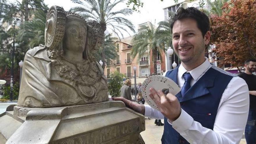 El ilusionista Joan Vidal hace un truco con la baraja de cartas en la plaza de la Glorieta momentos antes de actuar.