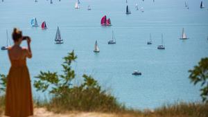 Una mujer toma una foto de los barcos que compiten en la 52a cinta azul alrededor de la carrera del lago Balaton, cerca de Balatonfured, Hungría.