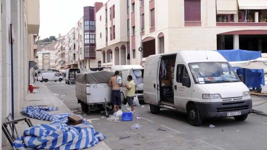 Mercaderes desmontan sus puestos en las calles del barrio de Los Huertos, ayer en Orihuela.