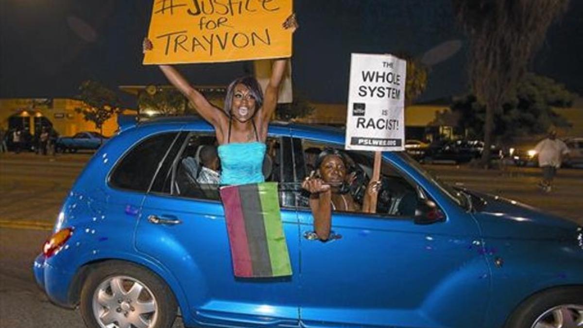 La protesta 8 Unas manifestantes exigen justicia en Los Angeles por el asesinato deTrayvon Martin.