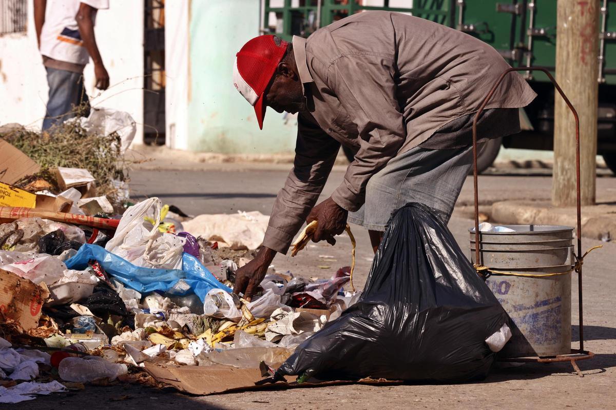 Un hombre rebuscando entre la basura en La Habana.