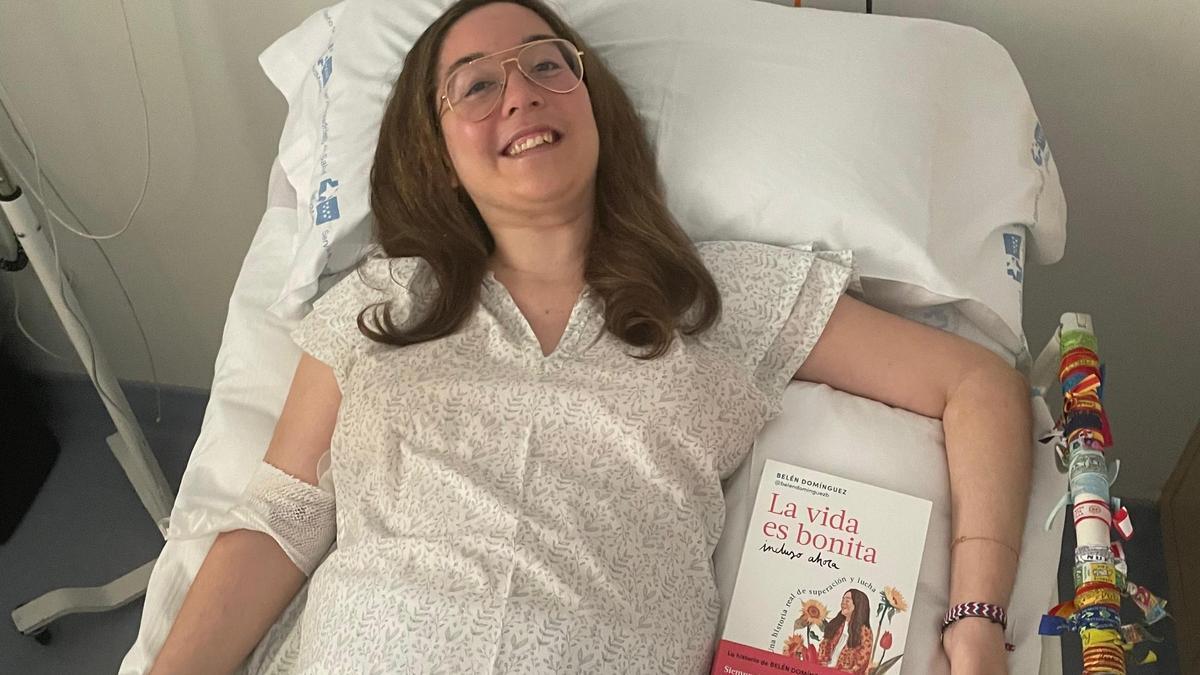 Belén Domínguez posa con su libro desde la cama de su habitación en el Hospital Ramón y Cajal.